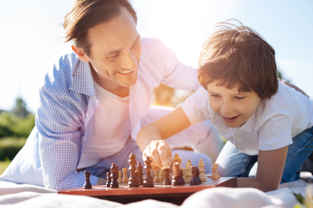 Папа играет в шахматы. Семья играет в шахматы. Отец и сын играют в шахматы. Фото папа с сыном и шахматами.